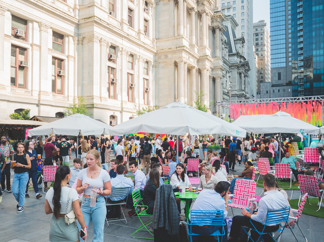 People gather and sit in colorful lawn chairs outside of City Hall in Dilworth Park for CCD SIPS.