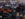 People walk through a busy convention center filled with new cars and SUVS at the Philadelphia Auto Show.