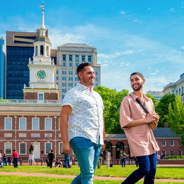 Two men walk through Independence Mall with Independence Hall in the background.
