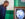 A man leans toward an old-fashioned television displaying black-and-white footage of Martin Luther King Jr., inside a museum style gallery with green walls.