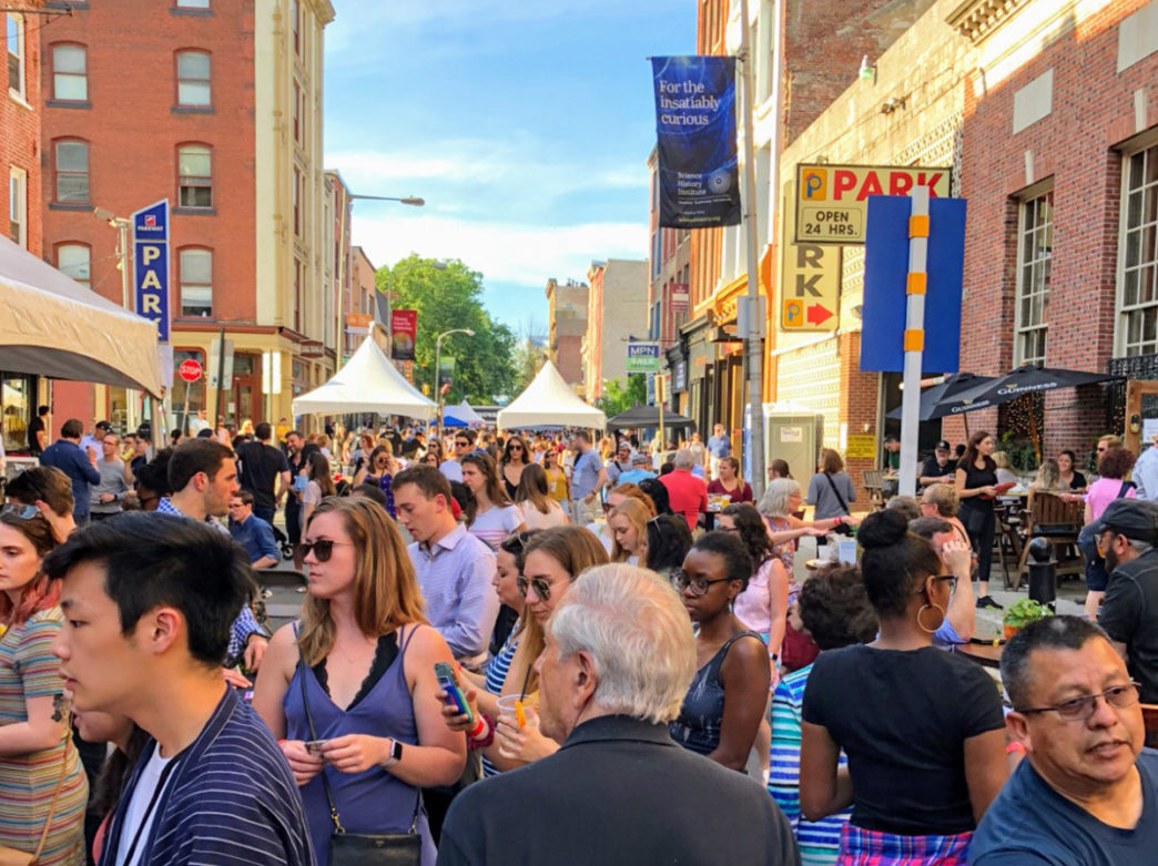 A crowd of people walks a street in Philadelphia during the Old City Eats Block Party