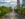 A photo of the Benjamin Franklin Parkway. Lush, green trees line the street, cars of a variety of models drive up and down the street, and City Hall can be seen in the background.