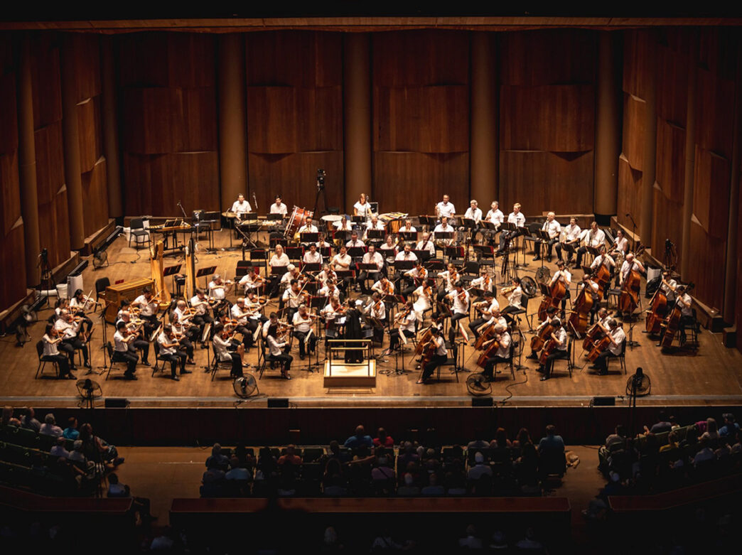 The Philadelphia Orchestra performs in front of a crowd at the Highmark Mann Center for the Performing Arts.
