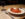 A plate of spaghetti and meatballs topped with red tomato sauce and parmesan cheese sits on a tabletop next to a glass of red wine.