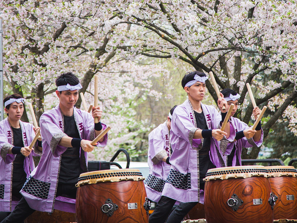Taiko performers play drums on stage at the Shofuso Cherry Blossom Festival