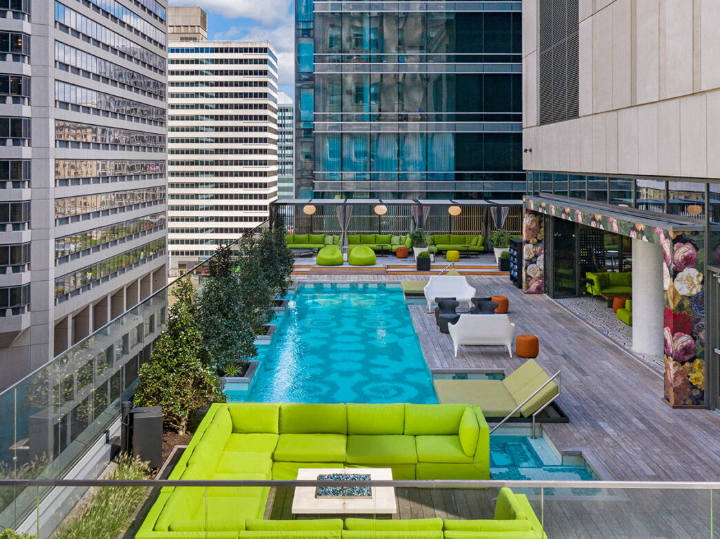 A rooftop pool with lime green lounge chairs and cabanas outdoors at the W Philadelphia.